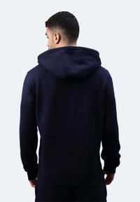 Felpa blu navy con un cappuccio ampio, maniche lunghe e polsini e orlo a coste, realizzata in un morbido tessuto testurizzato.