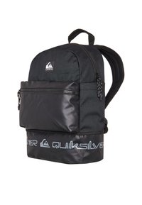 Mochila negra con una parte superior de tejido texturizado y un panel inferior brillante. Cuenta con un bolsillo frontal con cremallera y correas ajustables acolchadas.