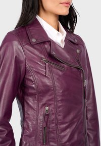 Fialová kožená motorkářská bunda se zipovými kapsami, s příložkou na límci a texturovaným povrchem, se zdobným prošíváním podél švů.
