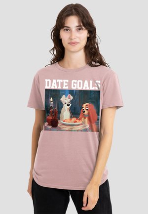 Light pink short-sleeve t-shirt featuring a graphic of two cartoon dogs sharing spaghetti, with the text "DATE GOALS" above.