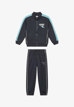 Completo tuta blu navy con giacca con zip e pantaloni jogger, presenta dettagli azzurri e piping bianco, realizzato in un tessuto morbido e strutturato.