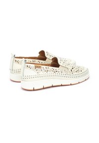 Zapatos blancos con cordones y un diseño floral recortado, un interior texturizado en tono marrón claro y una suela blanca gruesa con sutiles detalles de costura.