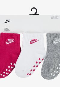 Trojdielny balíček dojčenských ponožiek obsahujúci ružové ponožky, biele ponožky s ružovými bodkami a sivé ponožky s bielymi bodkami; všetky majú protišmykové podrážky.