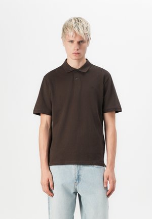 Bruine polo met een zachte katoenen stof, voorzien van een kraag, korte mouwen en een subtiele logodetail op de borst.
