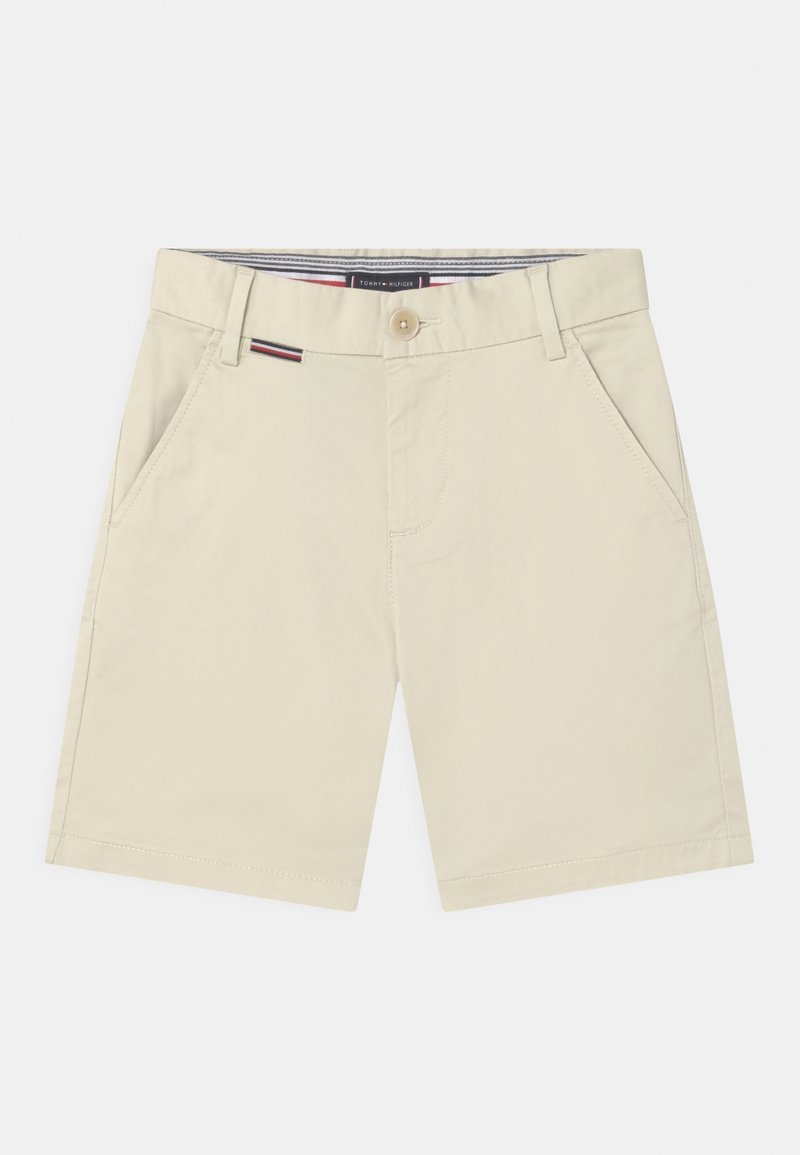 Shorts beiges en coton, avec une fermeture à bouton, des poches latérales et une ceinture intérieure rayée. Texture lisse et coupe ajustée.