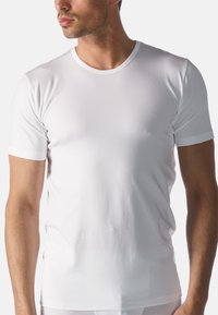 T-shirt bianco a girocollo, maniche corte, realizzato in tessuto liscio, design aderente, con dettagli delle cuciture minimi e una texture sottile.