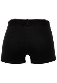 Μαύρες βαμβακερές σορτσάκια με λεία υφή, που διαθέτουν μέσης ύψους ελαστική ζώνη και μικρή κοπή στο πίσω μέρος, χωρίς επιπλέον σχεδιαστικά στοιχεία.