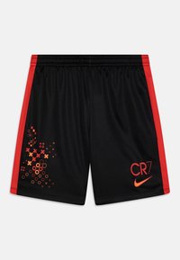 Shorts deportivos negros con paneles laterales rojos, patrones geométricos en rojo y naranja en la pierna izquierda, y "CR7" en rojo con el swoosh de Nike en la pierna derecha.