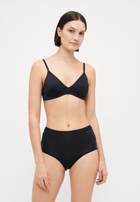 Svart bikini-sett med myk, glatt stoff. Toppen har en trekantet design med tynne stropper, og bunnene har høy midje.