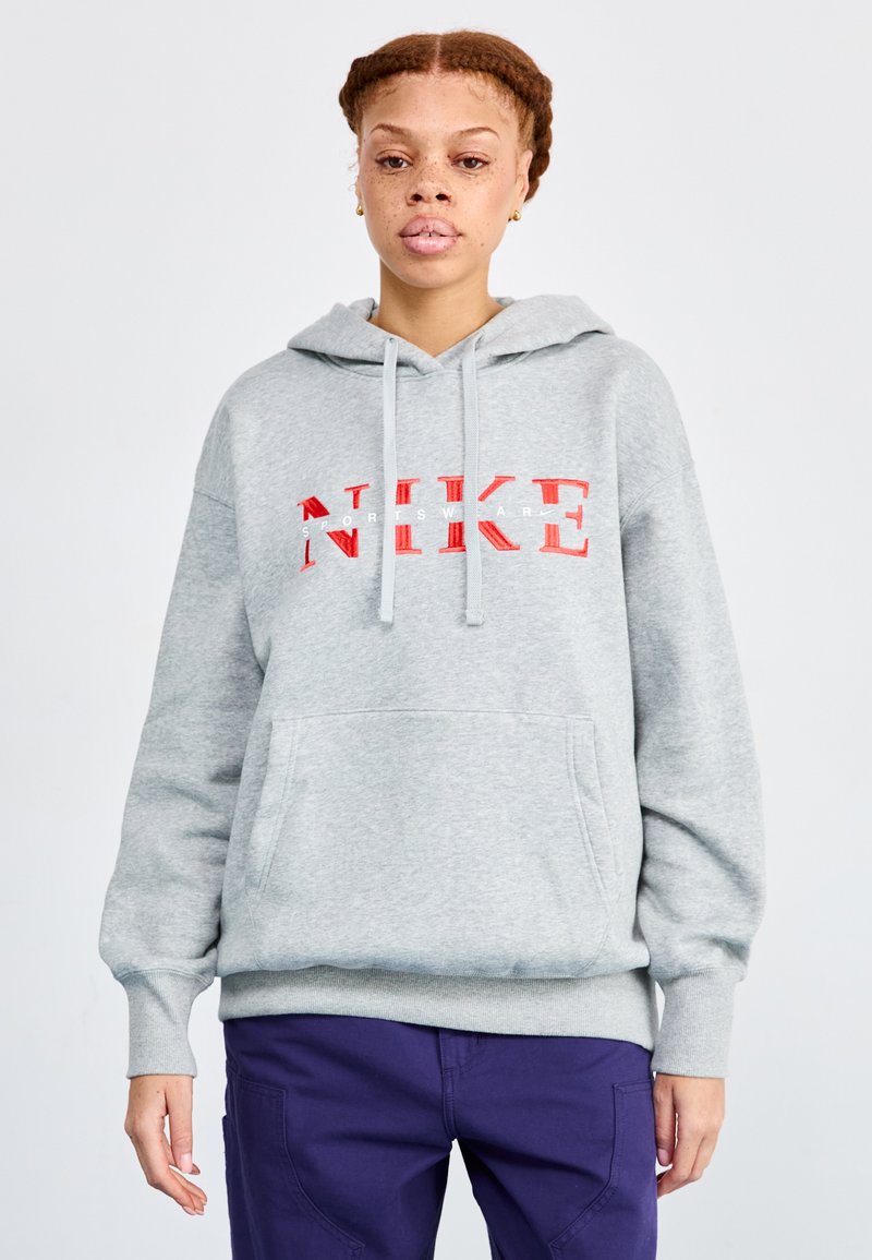 Pilkas džemperis su priekine kišene, su raudonu "NIKE" logotipu. Minkšta medžiaga, su raišteliu reguliuojama kapisonas, elastinės rankogaliai ir apatinė dalis.
