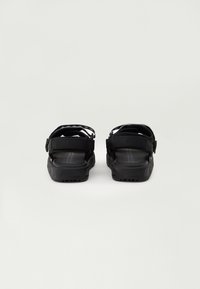 Sorte sandaler med justerbare remmer, en strukturert fotseng og en robust såle. Har kontrasterende detaljer på remmene for ekstra stil.