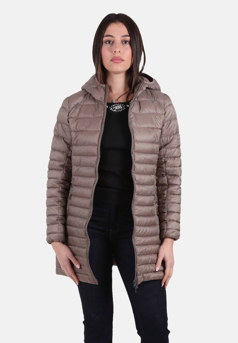 Cappotto imbottito marrone con cappuccio, caratterizzato da un design trapuntato, cerniera frontale e tasche laterali. Indossato sopra una maglia nera e jeans.