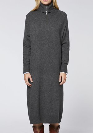 Gray, knitted turtleneck dress with a half zip, featuring ribbed cuffs and hem, worn over a white collared shirt.