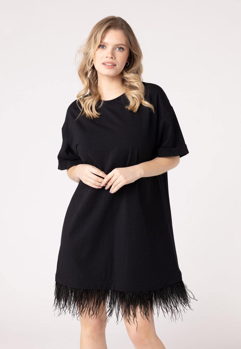 Fekete, oversize t-shirt ruha, rojtos aljjal, puha anyagból készült, felgöngyölt ujjal. Sima textúra, egyedi díszítéssel az alján.