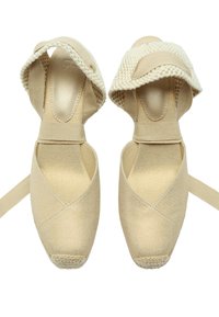 Beżowe baletki z materiałową cholewką i krzyżującymi się paskami. Okrągły czubek z tkaninowym noskiem. Gładka faktura w całym projekcie.