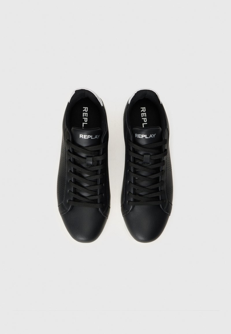 Zapatos deportivos negros con un diseño elegante y detalles en blanco, con cordones, un logotipo en la lengüeta y un detalle texturizado en el lateral.