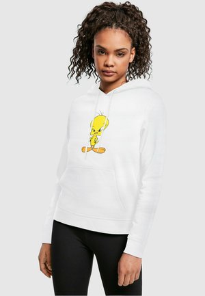 Hvit hettegenser laget av bomullsblanding med en gul Tweety Bird-grafikk på fronten, med kengurulomme og ribbestrikkede mansjetter.
