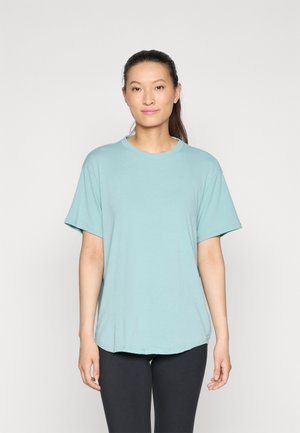 Lichtblauwe, T-shirt met korte mouwen in een ontspannen pasvorm met een ronde halslijn en een gladde textuur, gecombineerd met zwarte leggings.