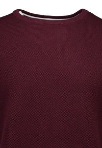 Burgunderfarbener Strickpullover mit rundem Halsausschnitt und strukturiertem Muster. Weicher Stoff, mittlere Dicke, leicht dehnbar und nahtlose Bündchen.