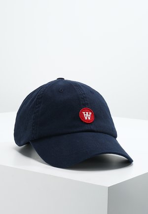 Mørkeblå bomullsbasketcap med en rund rød lapp med en hvit "W"-logo, buet skygge og justerbar stropp på baksiden.