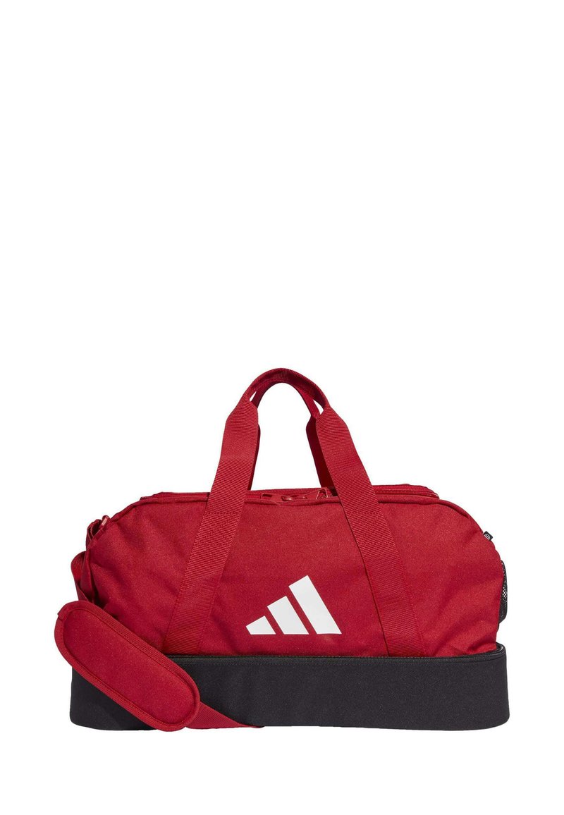 Bolsa de lona roja con asas dobles, cierre de cremallera, base negra y logotipo blanco; hecha de un tejido duradero con una textura suave y líneas limpias.