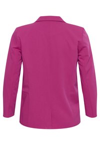 Blazer aderente di un brillante colore rosa, con un tessuto liscio, maniche lunghe, rever a coda di rondine e due tasche laterali. Dettaglio della piega sul retro visibile.