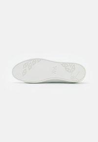 Suola di sneaker bianca con un design liscio, caratterizzata da un motivo a foglia e un sottile dettaglio del marchio. La texture è piatta senza ulteriori accenti.