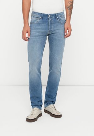 Light blue denim jeans with a straight cut. Features front and back pockets, five belt loops, and a zip-fly closure, paired with grey sneakers.