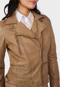 Braune Leder-Motorradjacke mit Reißverschluss vorne und seitlichen Taschen, Druckknopfkragen und verstellbaren Seitenriemen. Glatte Textur und taillierte Passform.