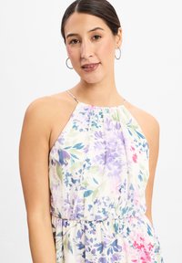Bloemendress met paarse, roze en groene tinten, met een halterhals en een gathered taille. Gemaakt van lichte, gestructureerde stof.