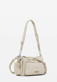 Borsa a tracolla in pelle beige con tracolla regolabile, tasche con zip e dettagli a nodo. Texture liscia con dettagli in hardware argentato e logo.