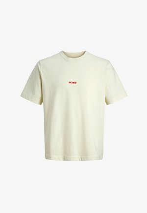 Kreemikas puuvillane t-särk lühikeste varrukate ja ümmarguse kaelusega. Rinnal on väike punane logo. Sile tekstuur, vabaaja stiil.