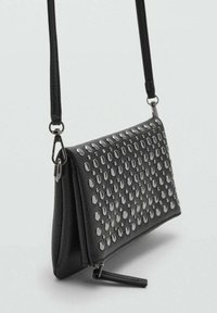 Borsa a tracolla in pelle nera con borchie metalliche, forma rettangolare, chiusura con zip e tracolla removibile. Superficie texturizzata con finitura liscia.