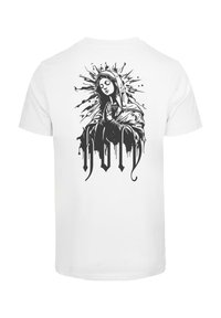 White short-sleeve t-shirt featuring a black graphic of a praying figure with a halo, surrounded by splatter design and the word "HOLY."