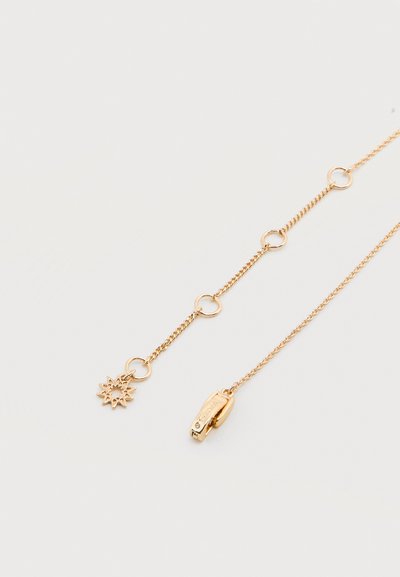 Λεπτό κολιέ με χρυσή αλυσίδα και στρογγυλές συνδέσεις, με ένα μενταγιόν σε σχήμα ήλιου στη μία άκρη και κούμπωμα με κλιπ αστακού στην άλλη.