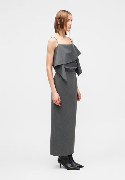 Robe grise avec détail de volants superposés au niveau de l'encolure, coupe ajustée et jupe longue jusqu'au sol. Comprend de fines bretelles et une texture de tissu.
