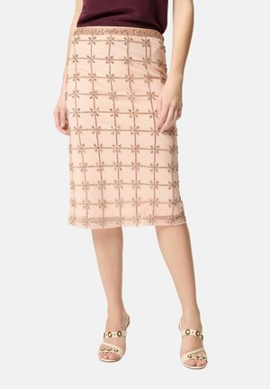 Gonna rosa pallido al ginocchio con motivo a griglia e decorazioni floreali con perline, indossata con top bordeaux e sandali beige con tacco.