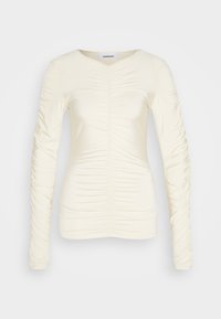 Langærmet creme top med samlet tekstur langs forsiden og ærmerne, V-halsdesign og en tætsiddende silhuet. Glat, strækbart stof.