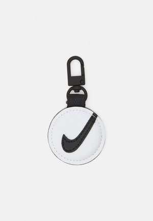 Kerek fehér kulcstartó fekete varrással, amelyen egy kiemelkedő fekete Nike Swoosh logó található. Fekete klipsz segítségével könnyen rögzíthető.