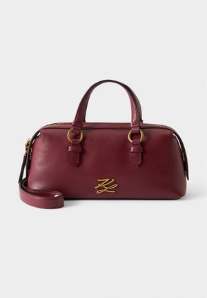 Sac à main en cuir bordeaux avec doubles poignées, une bandoulière amovible, logo doré et fermeture éclair.
