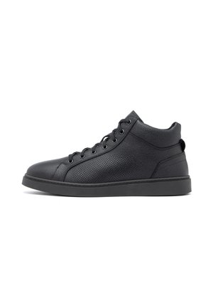 Czarny sneaker za kostkę z teksturowanej skóry, z przodu sznurowany, z wyściełanym kołnierzem i płaską gumową podeszwą, pokazany z profilu prawej strony na białym tle.