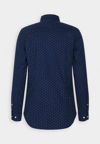 Tmavě modrá košile s dlouhým rukávem, zdobená vzorem diamantů, s knoflíkovými manžetami, standardním límečkem a zakřiveným sedlem. Hladká textura látky.