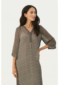 Robe transparente avec un motif en chevron marron et noir, décolletée en V et à manches trois-quarts, fabriquée dans un matériau léger.