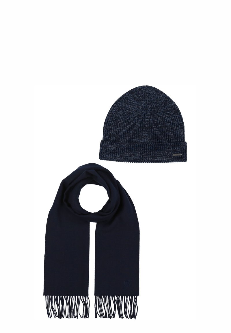 Cappello a maglia color blu navy scuro con una texture a coste e risvolto piegato, abbinato a una sciarpa lunga coordinata con estremità frange.