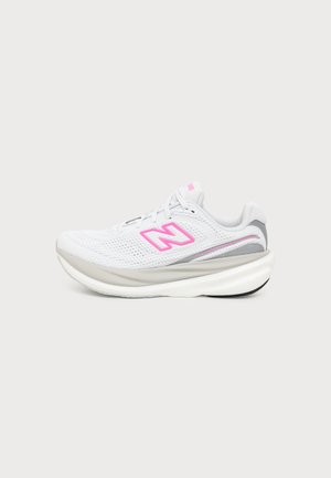 Chaussure de course blanche avec semelle épaisse, dessus en mesh, accents gris et logo rose vif contourné sur le côté, vue de profil.
