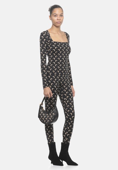 Body a motivo nero con forme a mezzaluna, taglio aderente e maniche lunghe. Abbinato a una borsa nera e a stivaletti neri con punta affusolata.