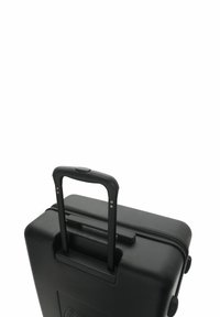 Black wheeled suitcase with a retractable handle, made from textured material, featuring a zipper closure and smooth wheels.