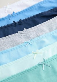 Sept paires de sous-vêtements en coton blanc, dans différentes nuances de bleu et de gris, chacune avec un petit nœud assorti sur la ceinture.