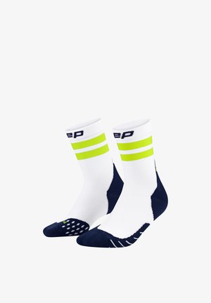 Weiße Sportsocken mit gelben und marineblauen Streifen, verstärkter marineblauer Zehenpartie und strukturiertem Grip-Muster an der Unterseite.
