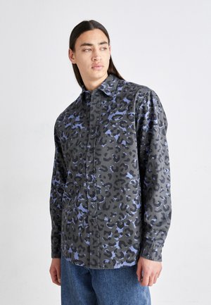 Schwarze Hemdbluse mit blauem Leopardenmuster, mit spitzem Kragen und langen Ärmeln, aus einem weichen, strukturierten Stoff gefertigt.